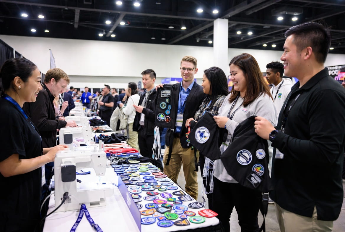 Corporate event attendees collecting custom embroidered patches at a live demo booth